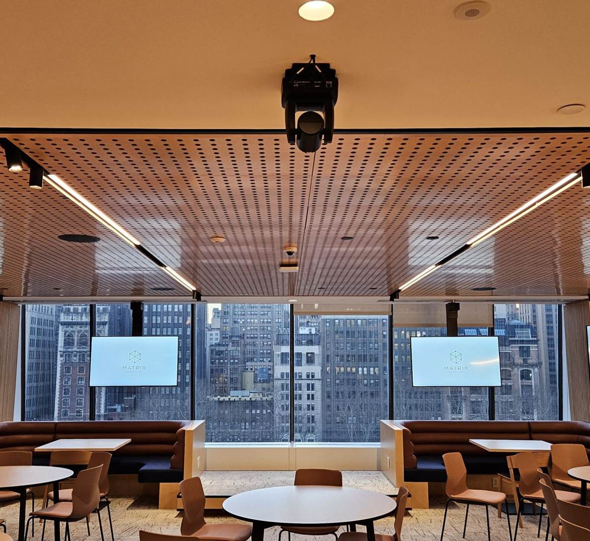 Amenity lounge with ceiling projector and displays overlooking Midtown