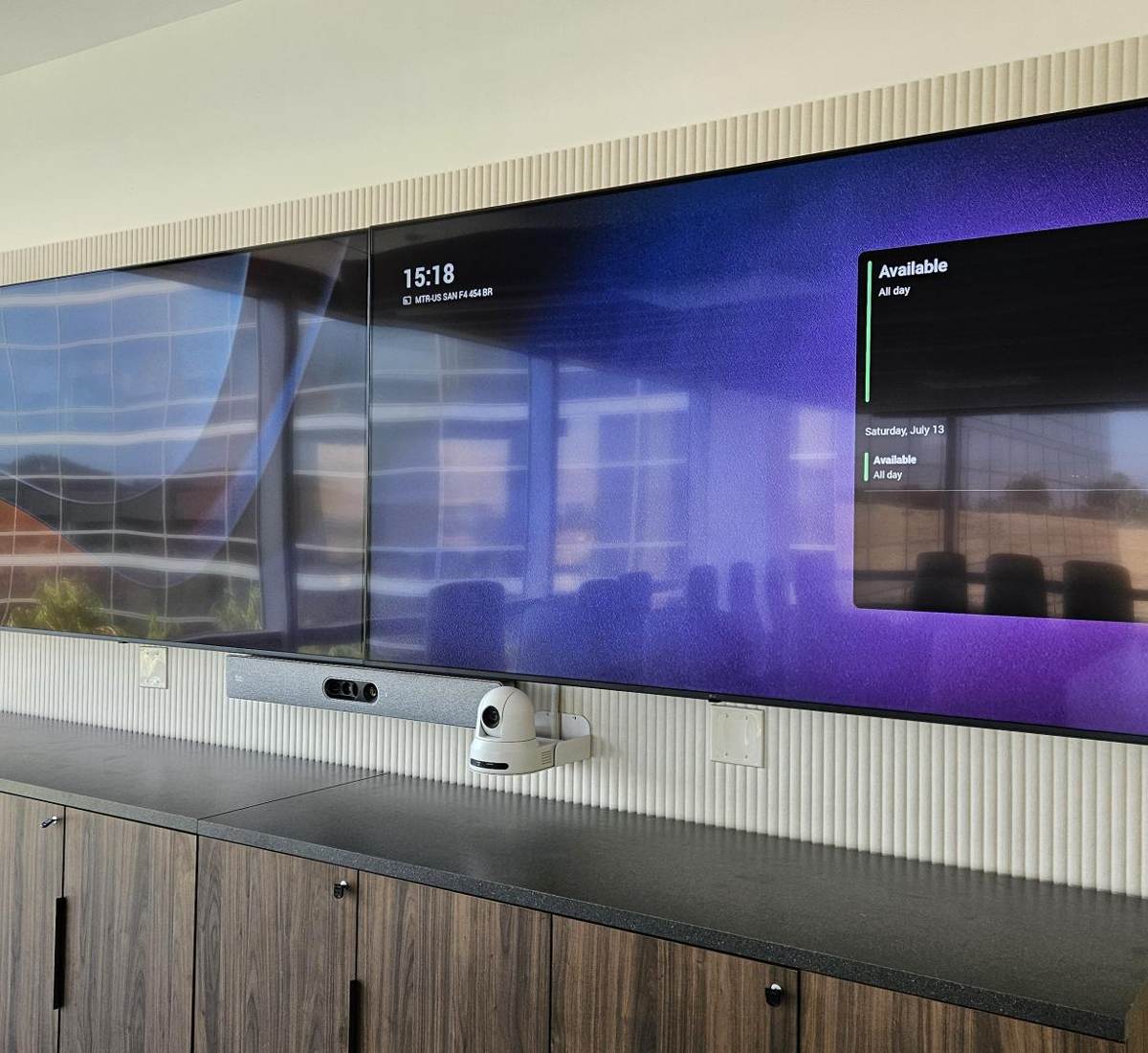 Boardroom video wall with PTZ camera, video bar and room scheduling display